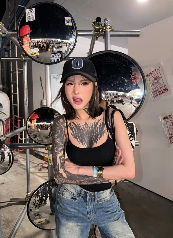 ครีเอเตอร์สาวยืนเดี่ยวในชุดลำลองกับหมวกแก๊ป